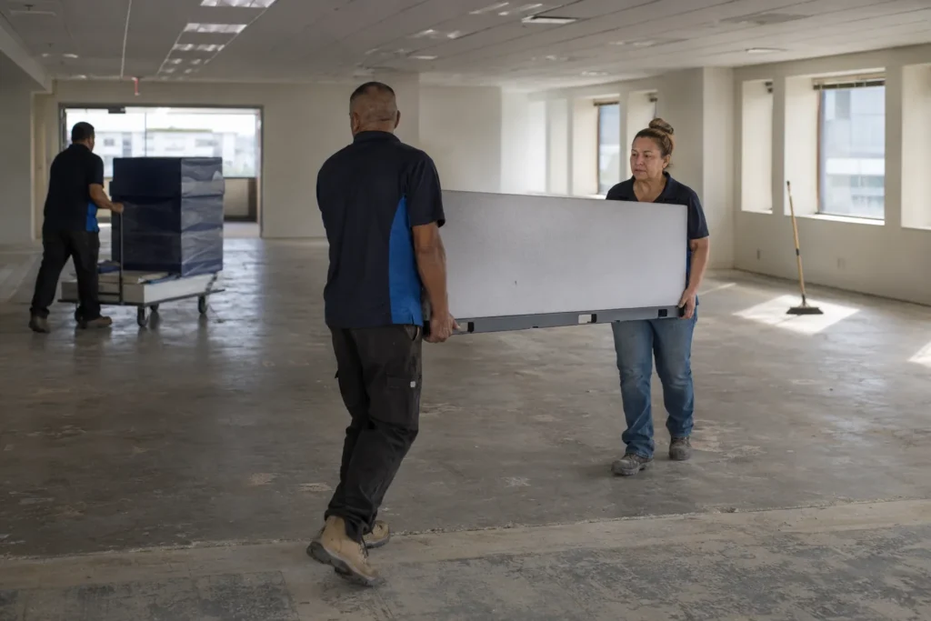 Flood Brothers crew clearing furniture and cubicles from an empty office floor against a lease deadline